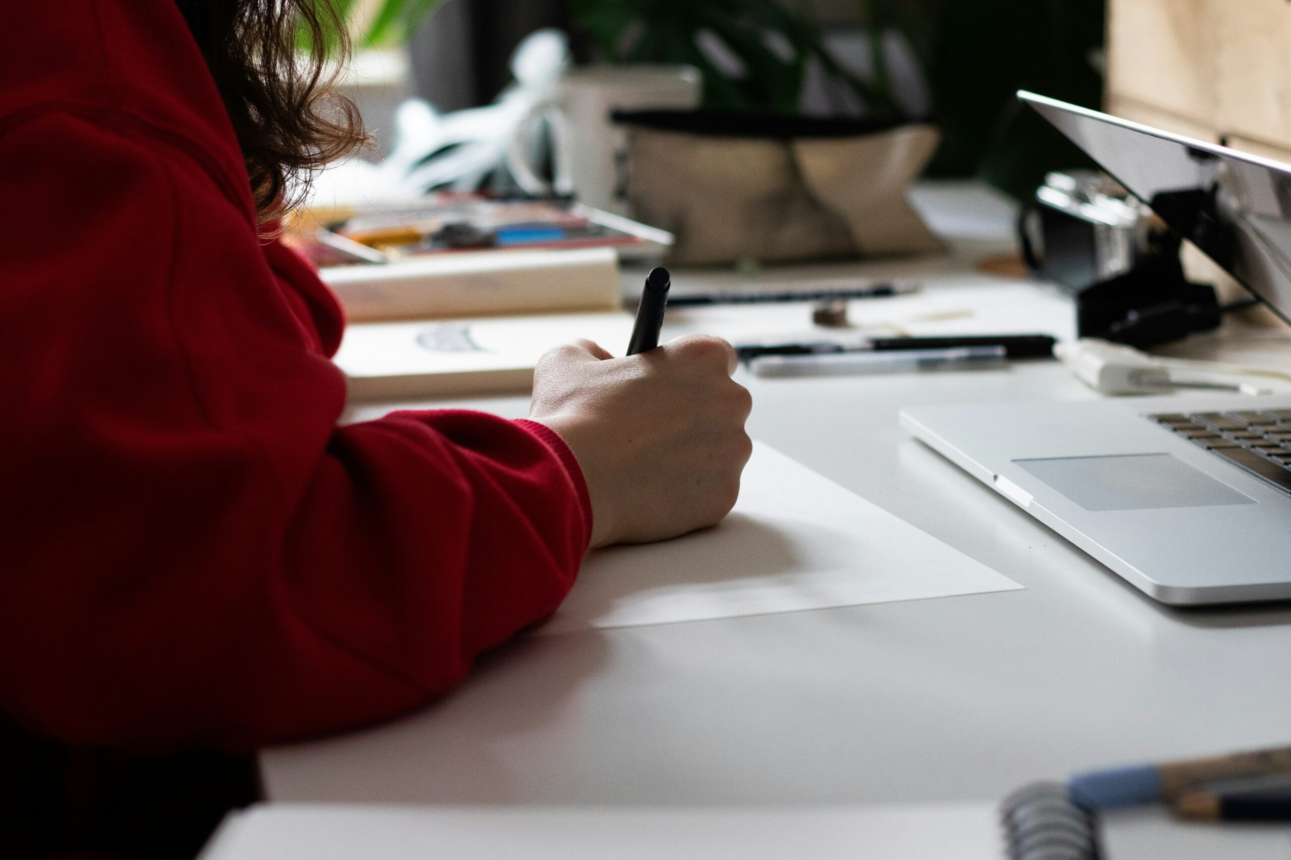 hand håller penna och skriver på papper